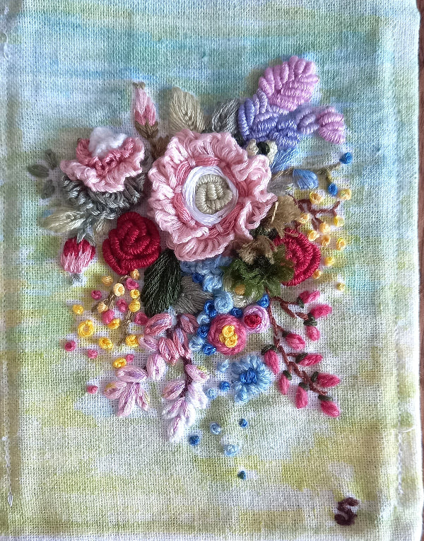 Bunch of hand embroidered 3d flowers in pastel colors and mounted in a frame with wooden finish