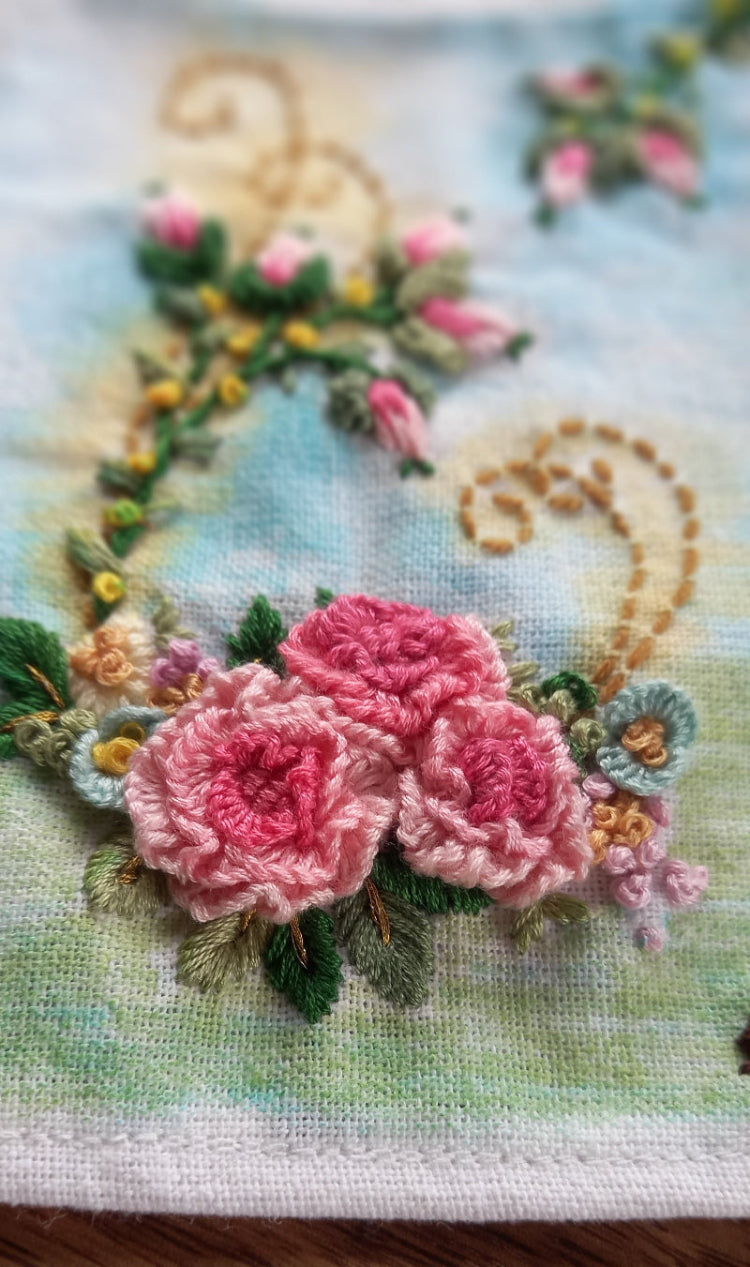 Delicate pink roses with embroidered rose buds on a lightly painted background to beautify home or workspace mounted in a modern frame.