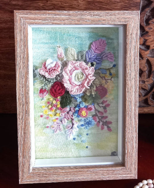 Bunch of hand embroidered 3d flowers in pastel colors and mounted in a frame with wooden finish