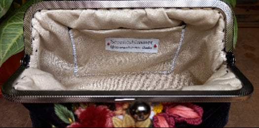 A sleek velvet purse with vintage look decorated with hand embroidered beautiful flowers, combining elegance and fun in one stylish piece.