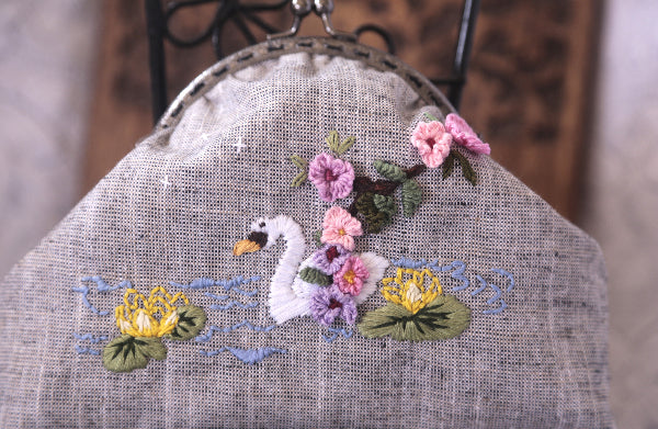 Hand embroidered swan and flowers on a linen purse, crafted with care, featuring a soft cotton lining.