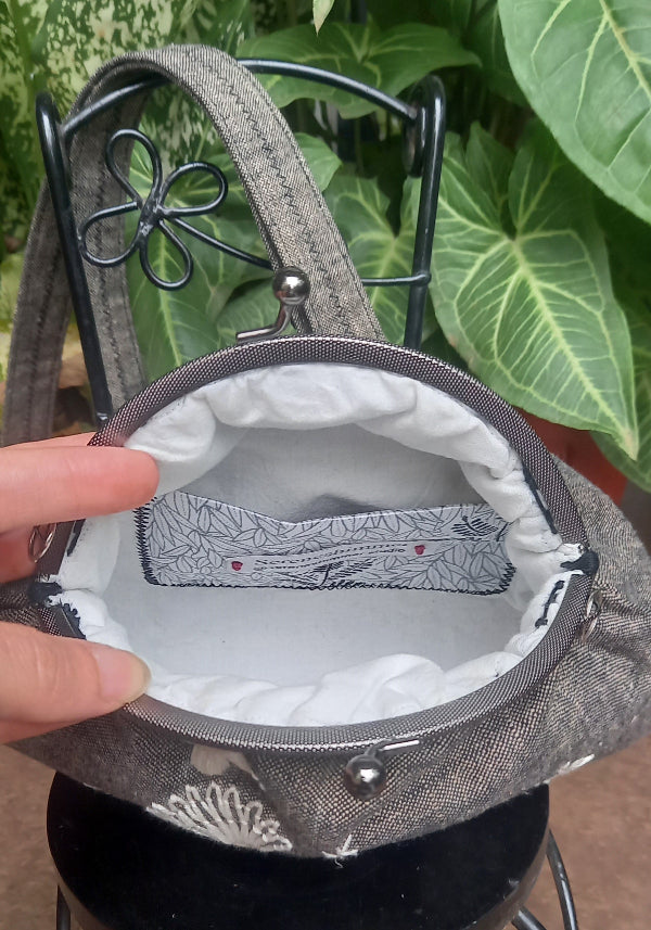 Handcrafted linen purse featuring vintage-style embroidered butterflies in silk thread with a cream monotone finish