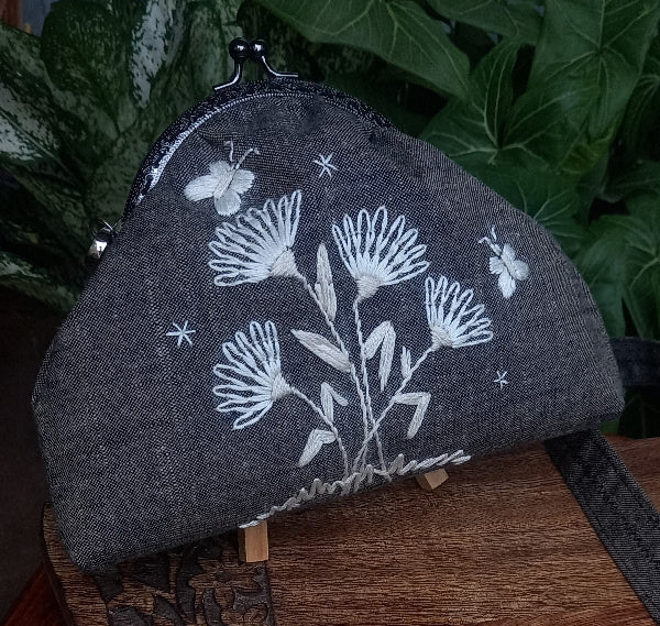 Elegant linen purse with hand-stitched silk thread butterflies, exuding a vintage charm in a soft cream monotone palette