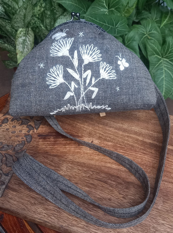 Vintage-inspired linen purse adorned with hand-embroidered butterflies in silk thread, showcasing a cream monotone design.