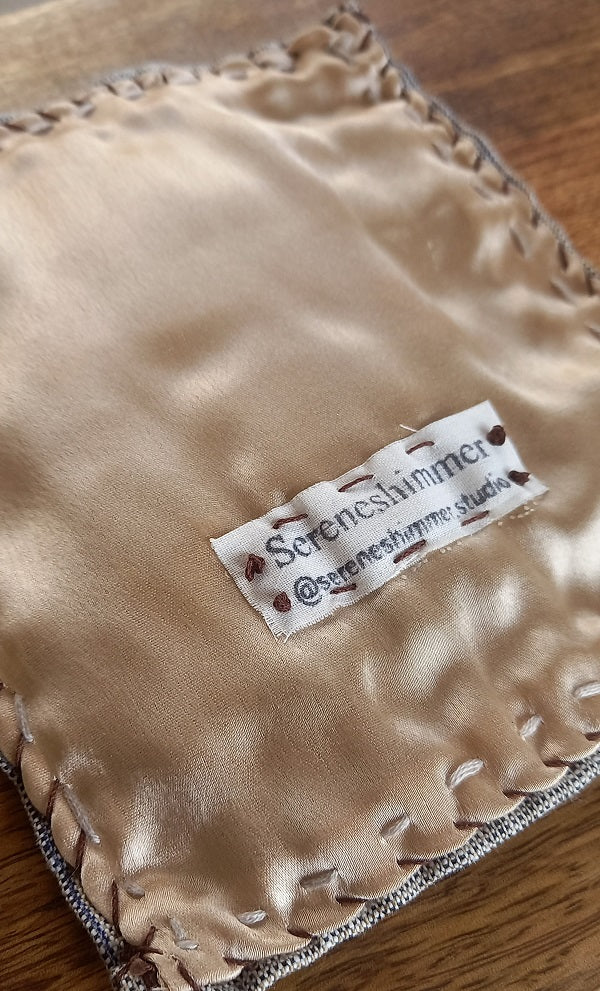 Delicate 3D roses in pink and pastel colors and greenery on velvet background and mounted on khadi linen fabric. The artwork is shown in rear view finished with cream satin fabric.