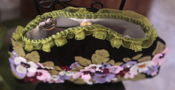 A vintage looking handbag featuring vibrant floral designs, ideal for a trendy accessory look