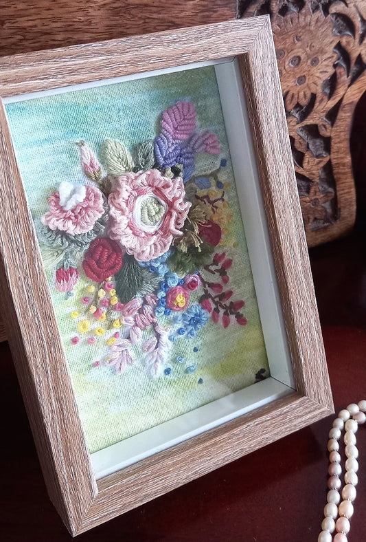 Bunch of hand embroidered 3d flowers in pastel colors and mounted in a frame with wooden finish