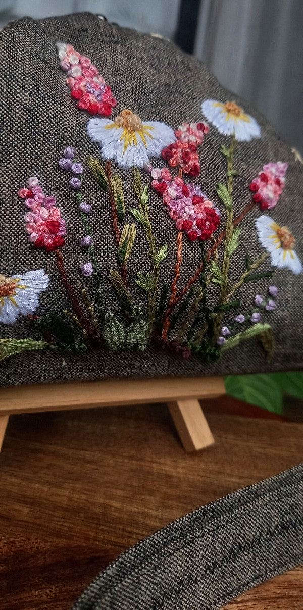 Handcrafted brownish khadi linen purse embellished with hand embroidery with pretty delicate white and pink wildflowers