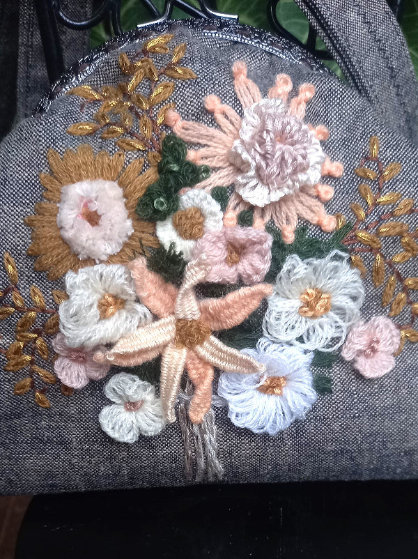 Delicate peach-colored flowers hand embroidered on a hand-crafted khadi linen purse