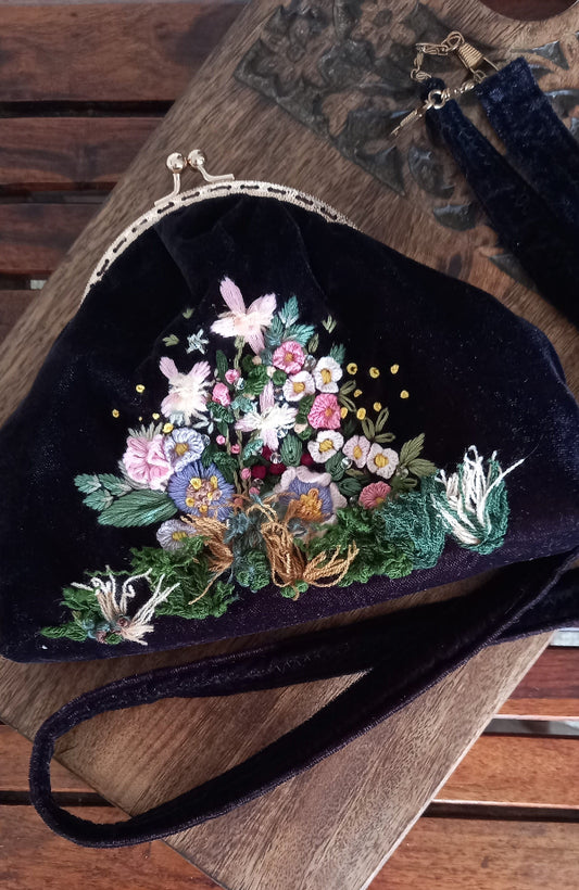 A sleek handcrafted velvet purse with vintage look decorated with hand embroidered beautiful flowers, combining elegance and fun in one stylish piece.