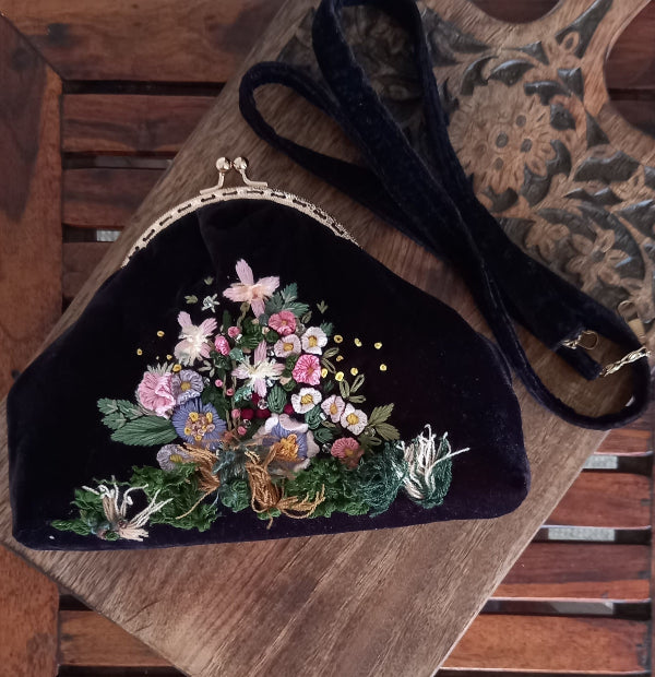 Vintage-inspired velvet purse with beautiful hand-embroidered flowers and leaves, showcasing exquisite craftsmanship.