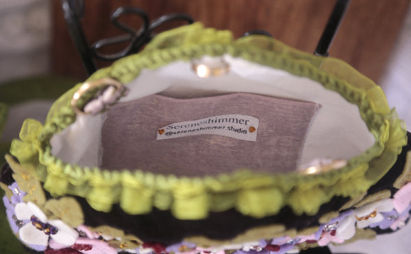 A vintage looking velvet purse decorated with beautiful flowers, combining elegance and fun in one stylish piece.
