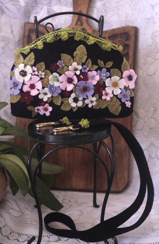 A chic handcrafted velvet purse featuring vibrant floral designs, ideal for a fashionable accessory to brighten your look.