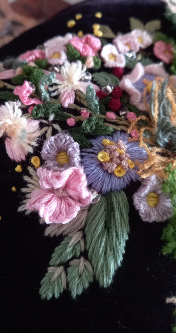 Elegant velvet purse with intricate hand-embroidered flowers and leaves, designed in a charming vintage style